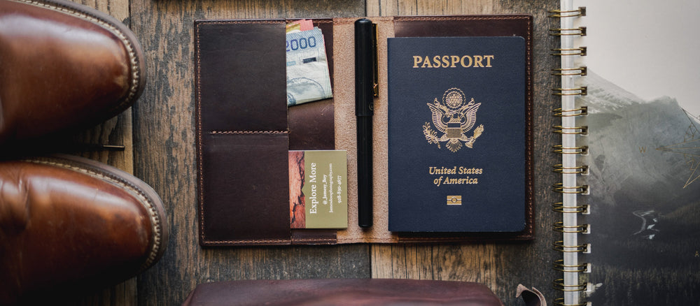 Passport and travel documents in a leather wallet on a wooden surface olpr